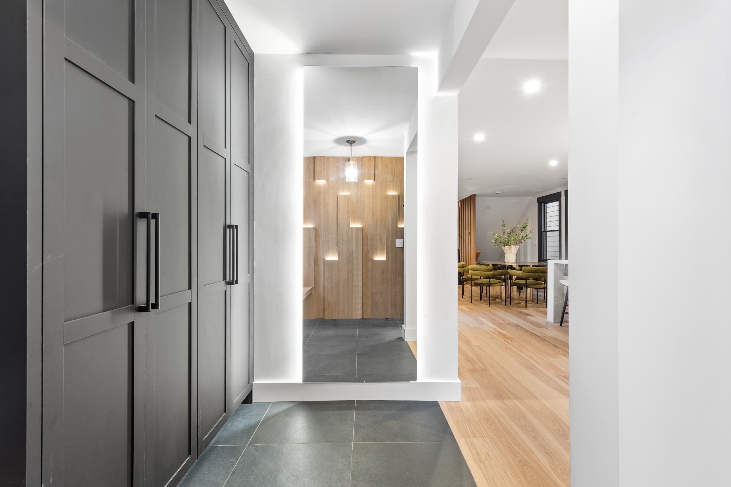 Mudroom with tall charcoal cabinets opening to the kitchen in a Kennebunk, Maine home